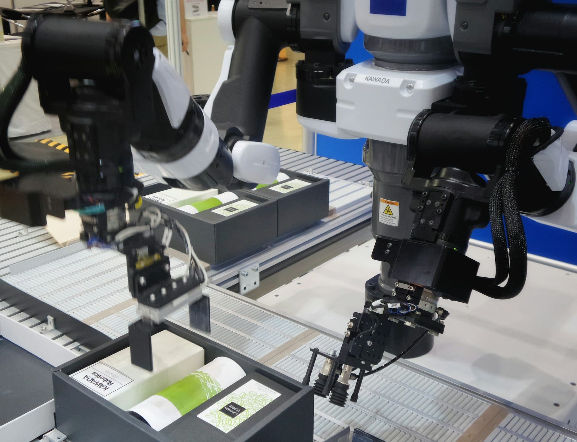 Robotic arms packing three different items into one box to make a uniform assortment package for a brand