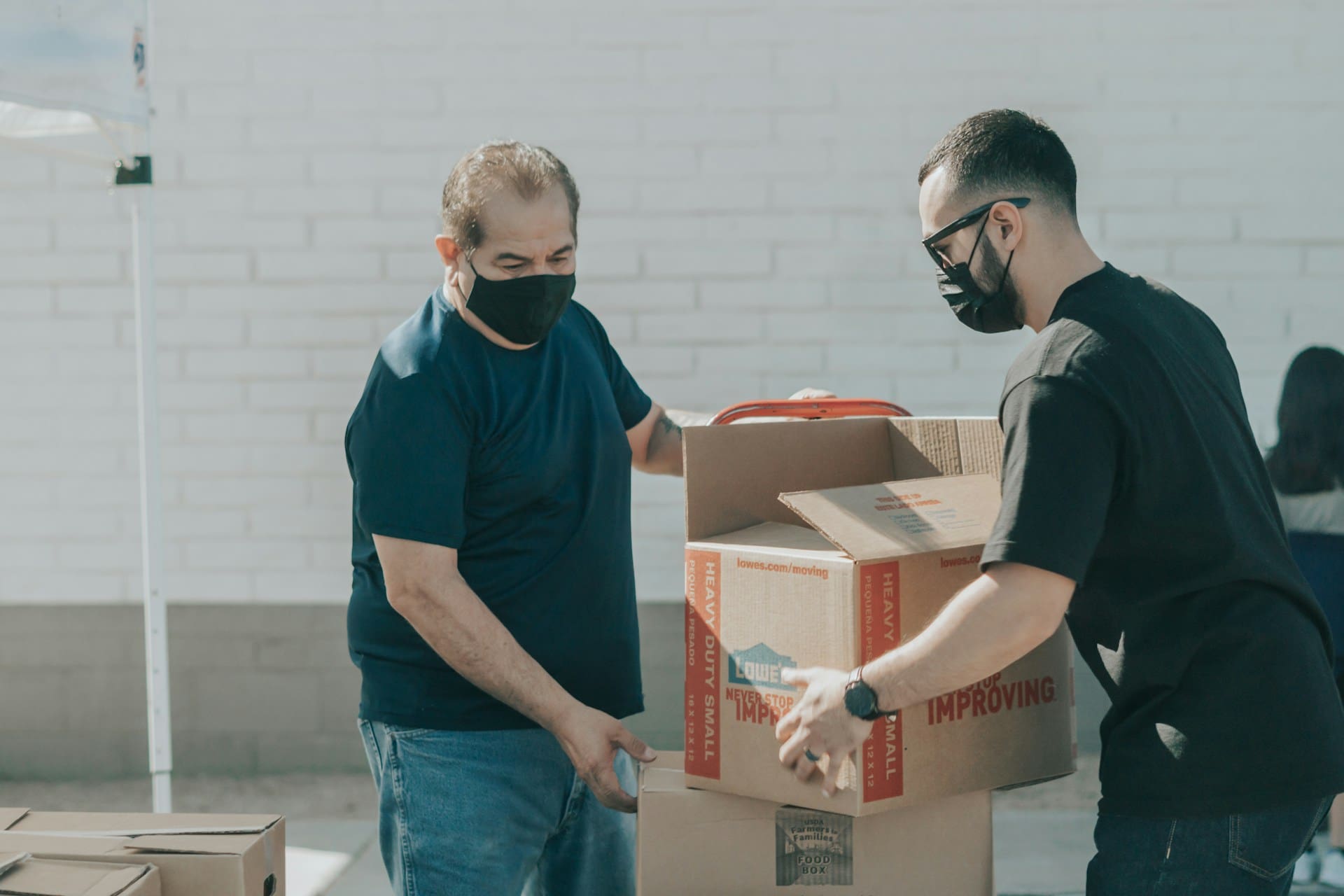 Two warehouse workers putting items into a box